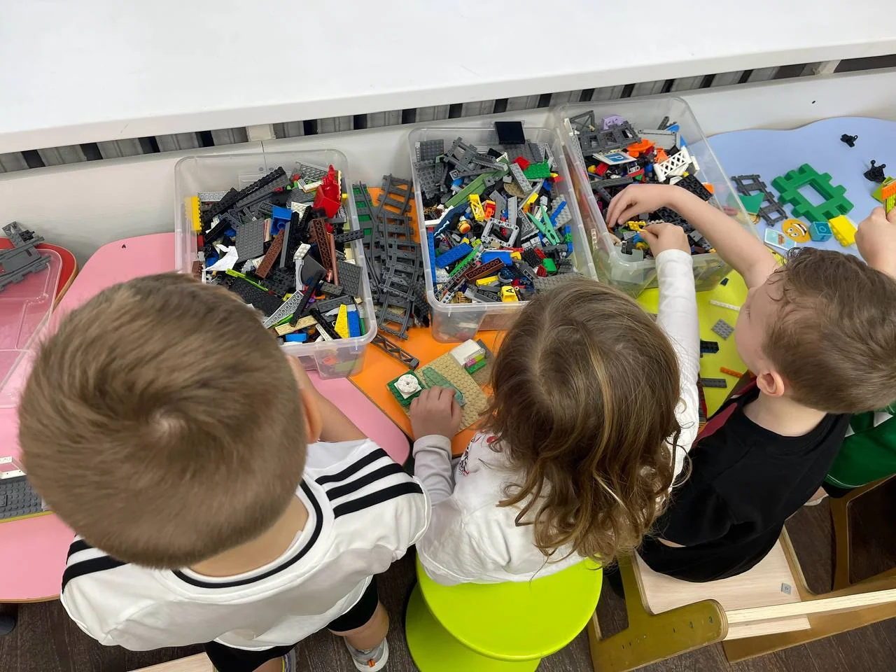 Дети Макарун вместе конструируют из LEGO за игровым столом